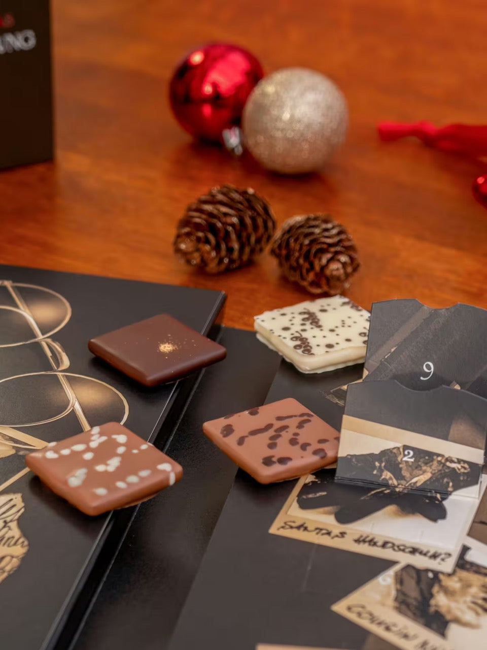 Einzelne Pecarée-Trüffeltäfelchen aus dem PETERS Criminal Christmas Adventskalender Die Verschwörung 255 g dekorativ angerichtet.