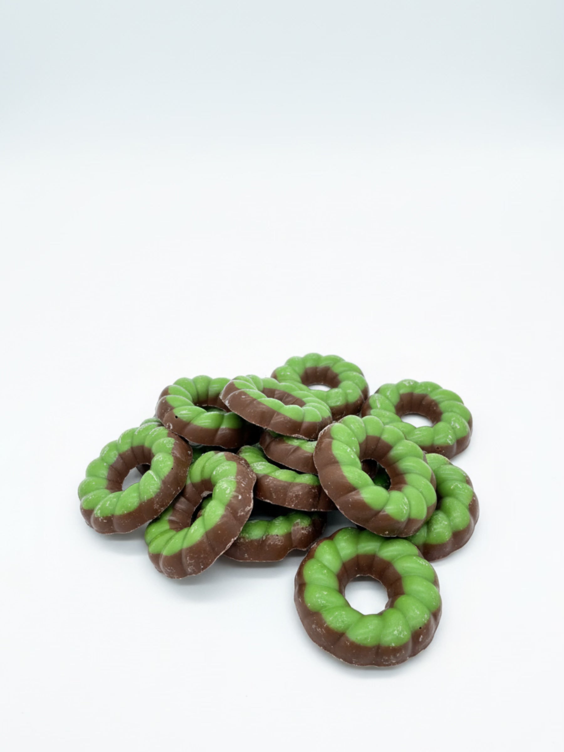 Produktfoto von X-Mas Schokoringe Vollmilch grün 100 g – feine Vollmilchschokolade mit weihnachtlicher Deko, erhältlich bei der Dreyer Confiserie in Hameln.