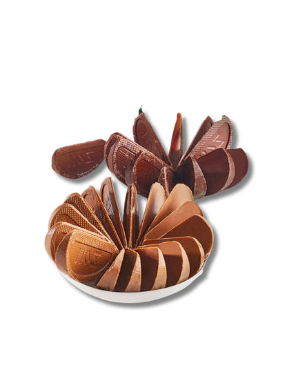 Produktfoto und Detailaufnahme von Tellapfel Zartbitter und Tellapfel Vollmilch erhältlich in der Dreyer Confiserie Hameln.