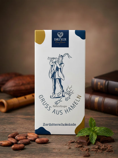 Verpackung von unserer Schokolade „Gruß aus Hameln“ Zartbitter 80 g – edle Zartbitterschokolade mit Motiv der Rattenfängerstadt Hameln, handgefertigt für die Dreyer Confiserie.