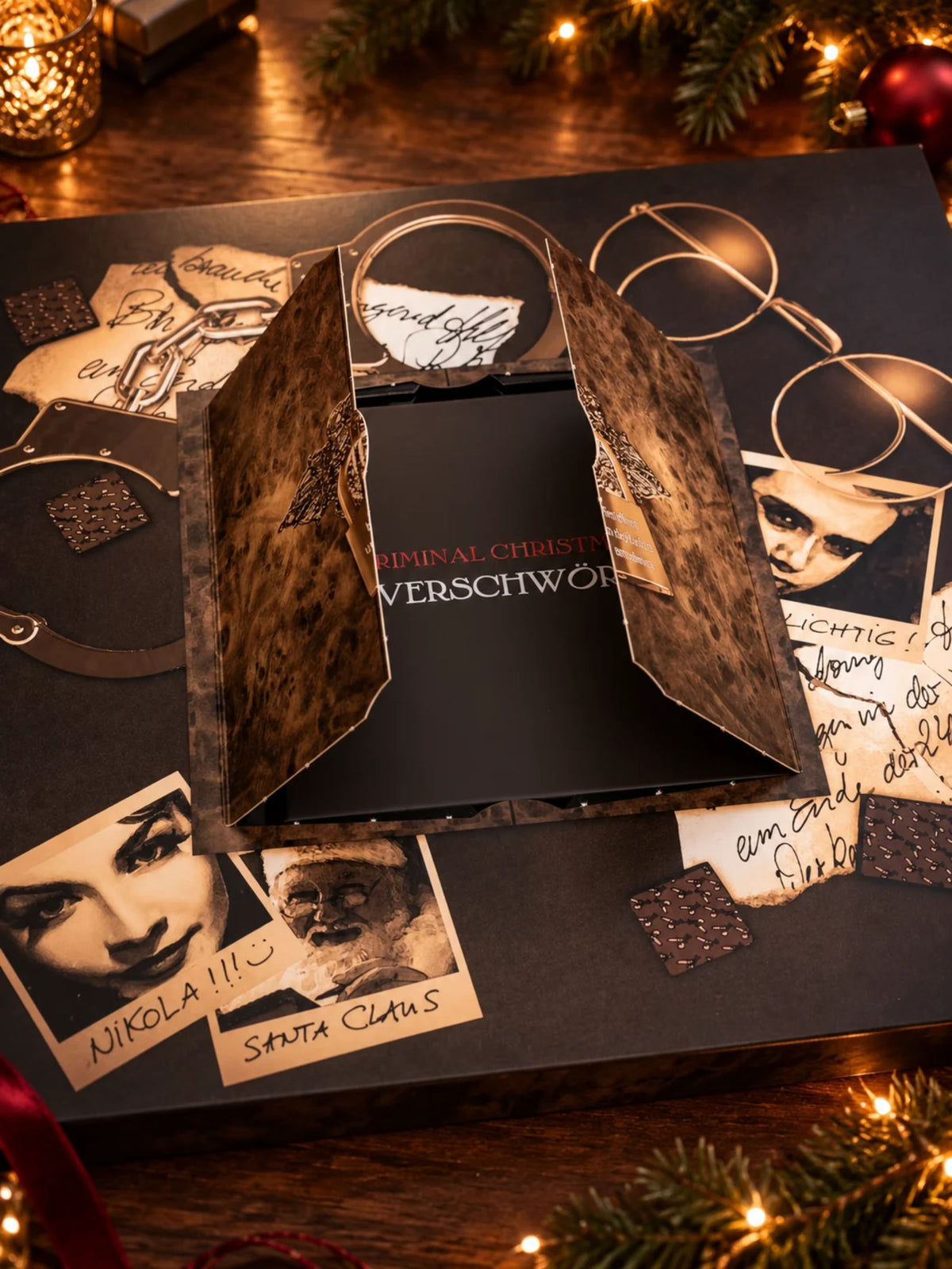 Aufgeklappter Criminal Christmas Die Verschwörung Adventskalender von PETERS Pralinen mit geheimnisvollem Innenfach, Kriminalfall-Motiv und versteckten Hinweisen