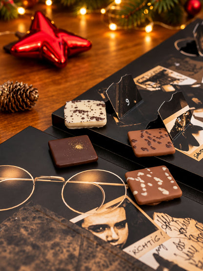 Criminal Christmas Die Verschwörung Adventskalender 255g von PETERS Pralinen mit geöffneten Türchen, Schokoladentäfelchen und weihnachtlicher Krimi-Dekoration