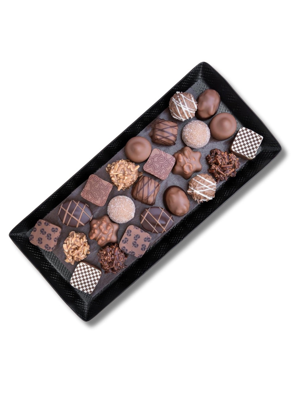 Auswahl der enthaltenen alkoholfreien Pralinen aus dem Adventskalender „Das Haus des Weihnachtswichtels“ 300 g von PETERS, dekorativ auf einem Teller angerichtet, erhältlich in der Dreyer Confiserie in Hameln.