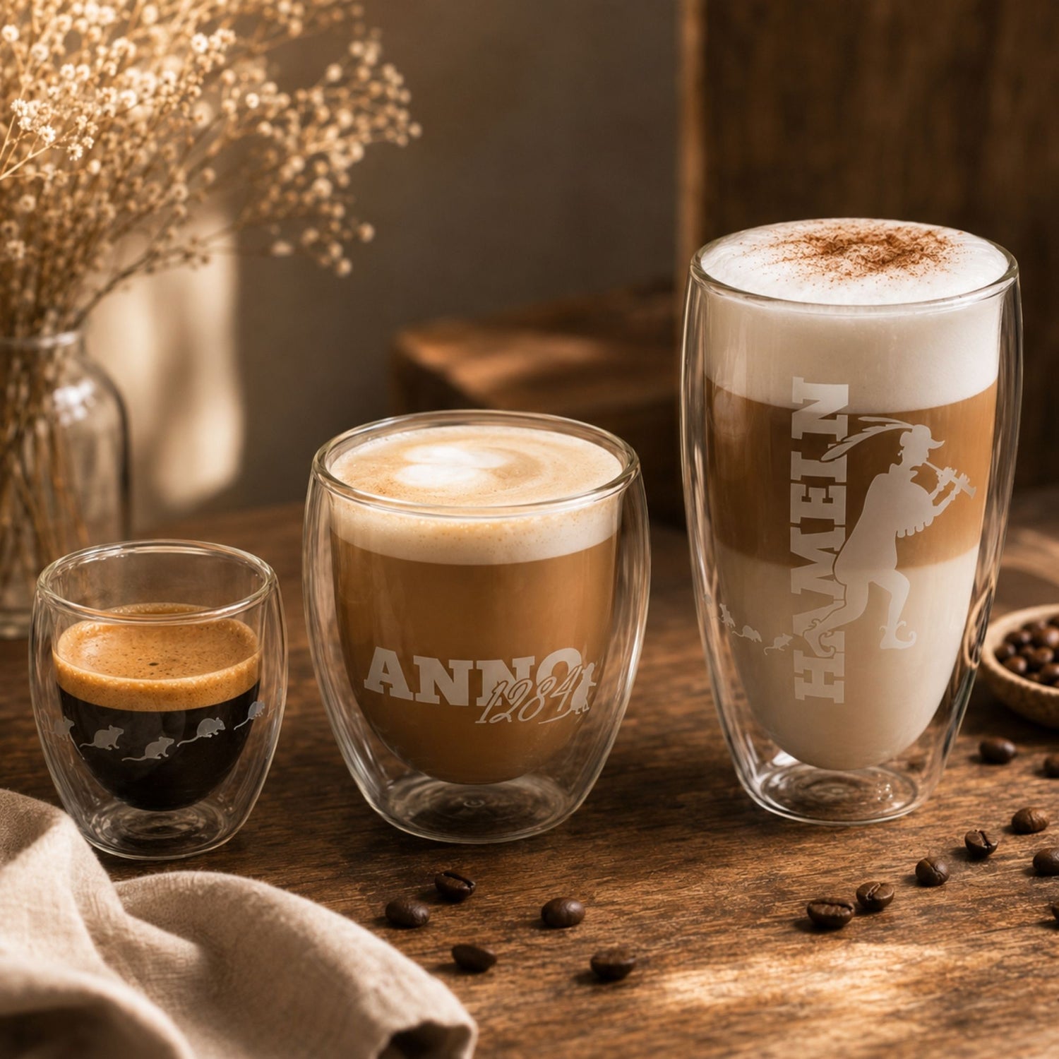 Espresso, Cappuccino und Latte Macchiato in passenden Gläsern und Tassen nebeneinander