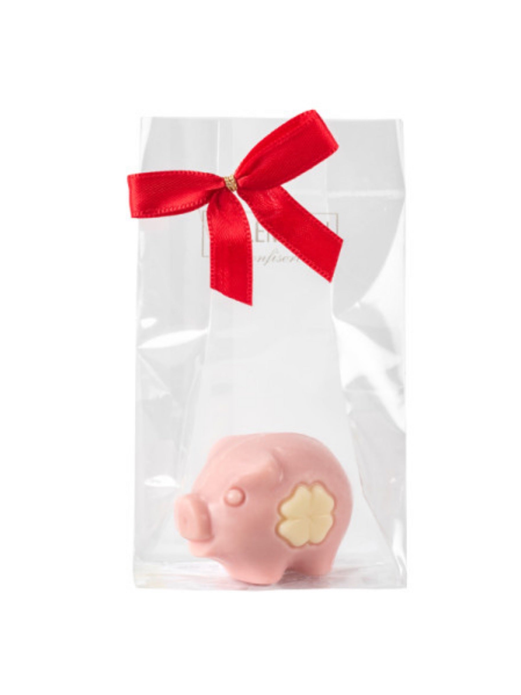 Glücksschweinchen rosa 15 g – süßes Schokoladen-Schwein aus rosa gefärbter weißer Schokolade mit Schleife aus weißer Schokolade, erhältlich in der Dreyer Confiserie in der Rattenfängerstadt Hameln.