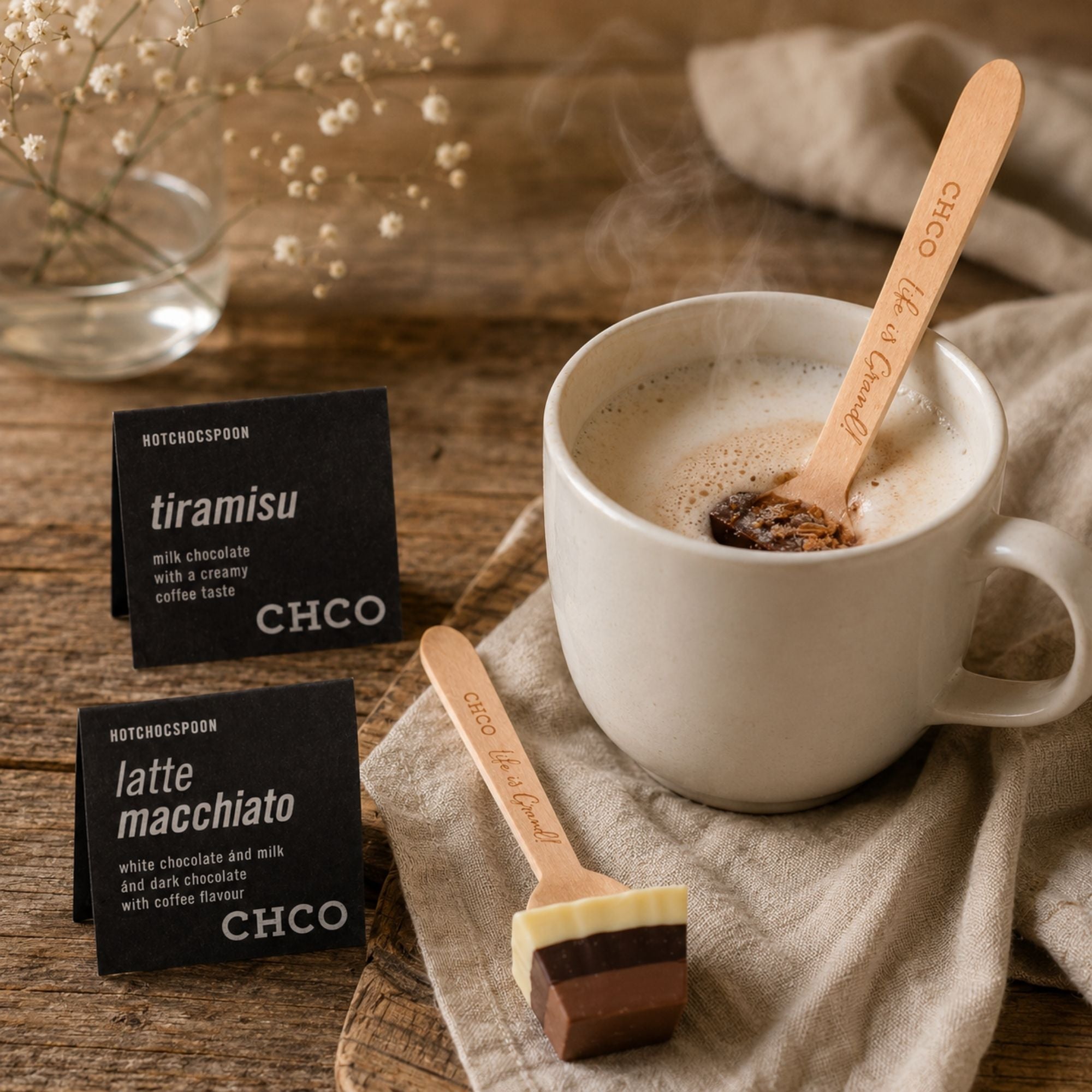 Schokolade am Holzlöffel zergeht in einer Tasse heißer Milch