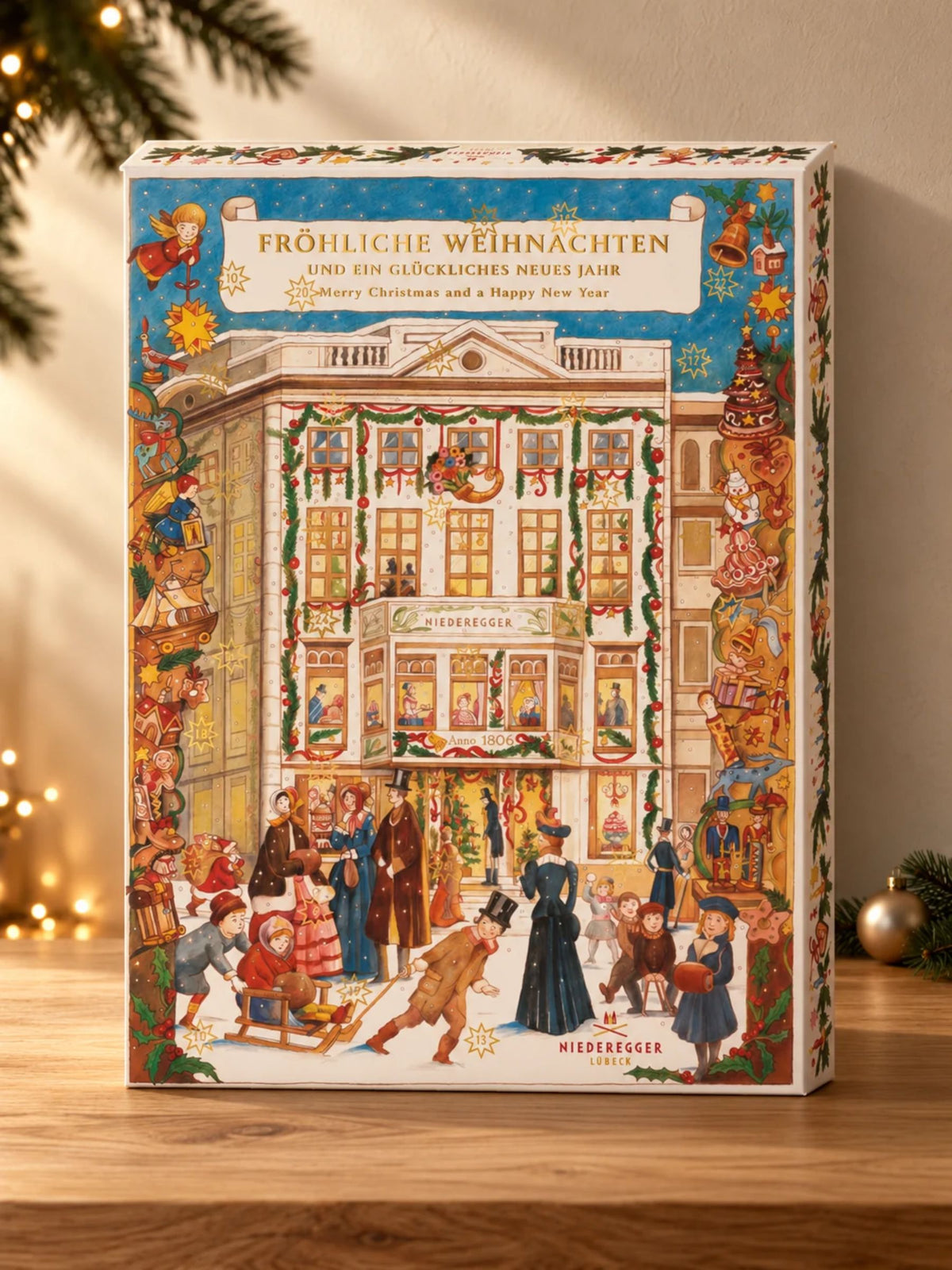 J.G.N. Adventskalender Café Niederegger 525g mit nostalgischem Motiv des festlich geschmückten Café Niederegger in Lübeck, winterlicher Stadtszene und weihnachtlicher Beleuchtung