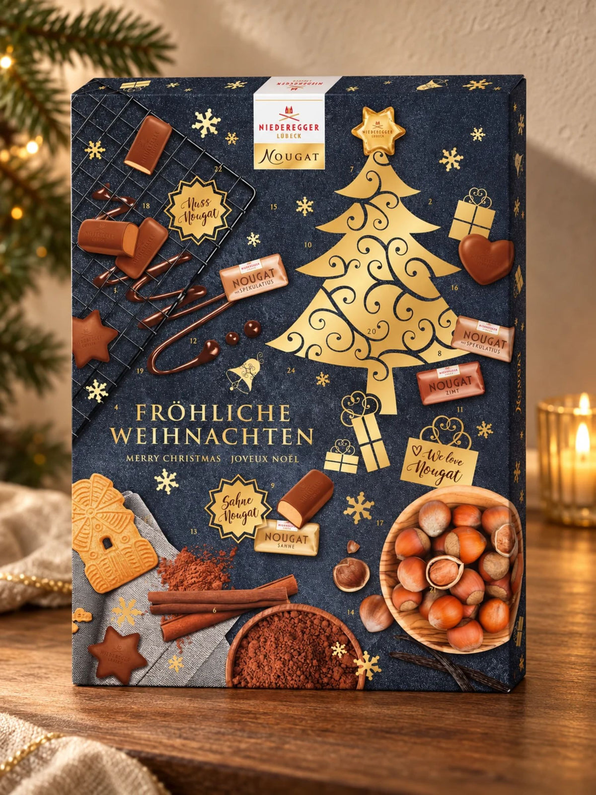 Niederegger J.G.N. Adventskalender Nougat 500g mit goldenem Weihnachtsbaummotiv, verschiedenen Nougatspezialitäten, Haselnüssen und festlicher Dekoration mit Tannenzweigen und Kerzenlicht