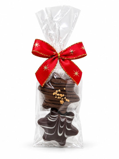 Maxi-Trüffelstern Duo Crème Brûlée und Honig 40g von Wagner Pralinen mit zwei Schokoladensternen in transparenter Geschenkfolie und roter Weihnachtsschleife