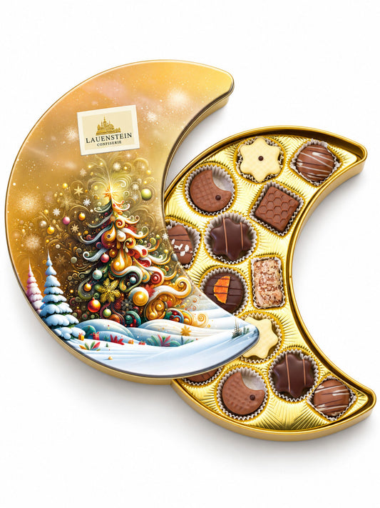 Pralinen Präsentdose Mond Gold alkoholfrei 175g von Lauenstein Confiserie mit Weihnachtsbaum und verschneiter Winterlandschaft auf goldfarbener Metalldose