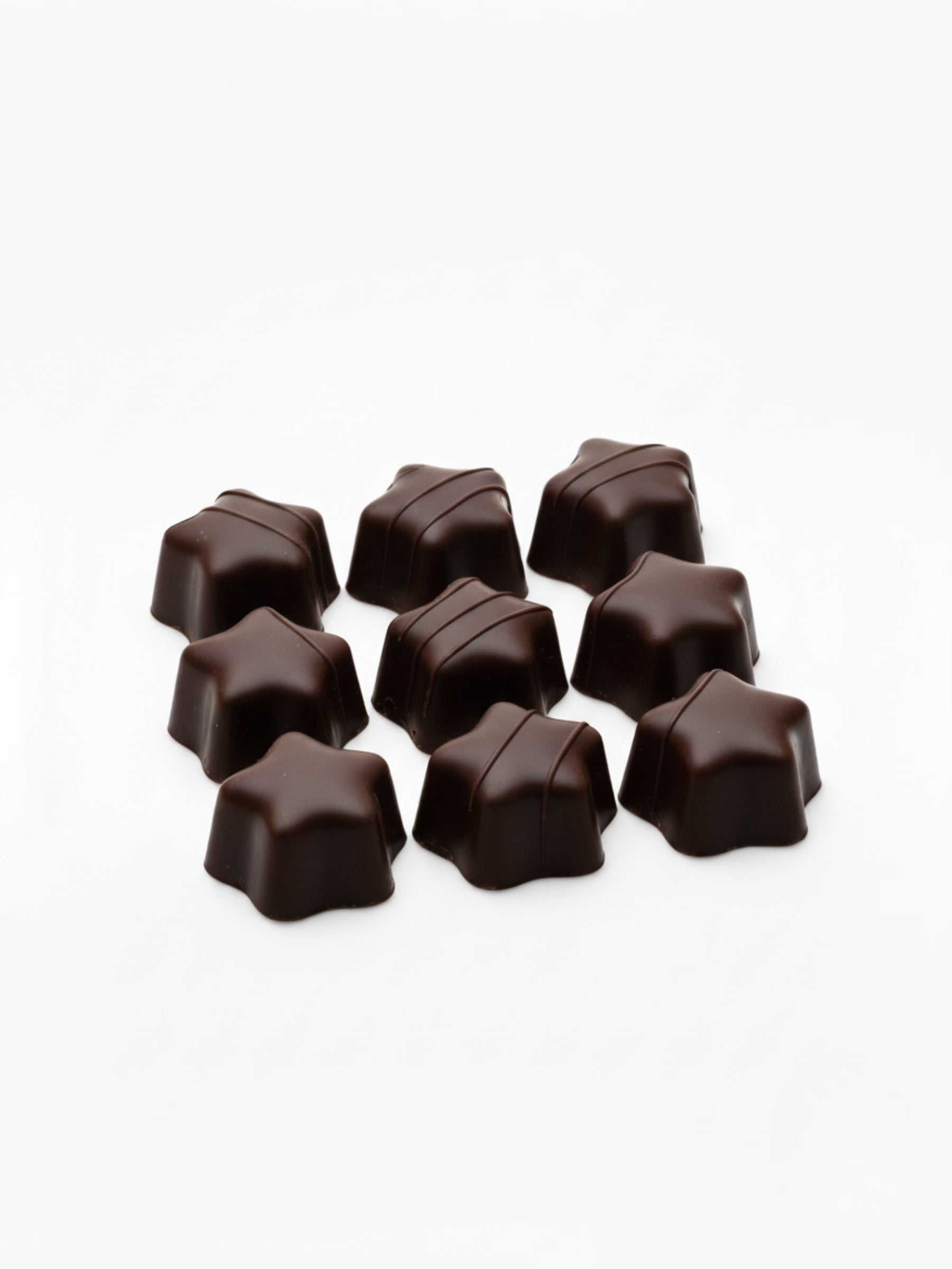 Produktbild von Weinbrand-Sterne Kruste 100 g – feine Sterne aus Bitterschokolade mit flüssiger Weinbrand-Füllung, ideal für den Bunten Teller, erhältlich in der Dreyer Confiserie in der Rattenfängerstadt Hameln.