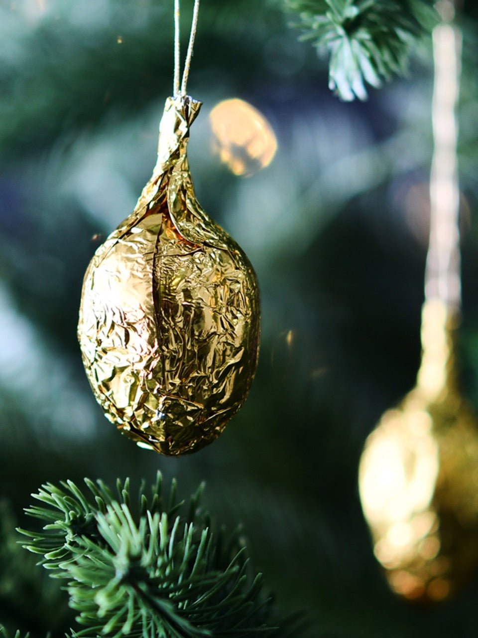 Detailaufnahme am Weihnachtsbaum ovn Sawade Goldnuss – Zartbitterschokolade mit Nussnougatfüllung in Goldfolie“