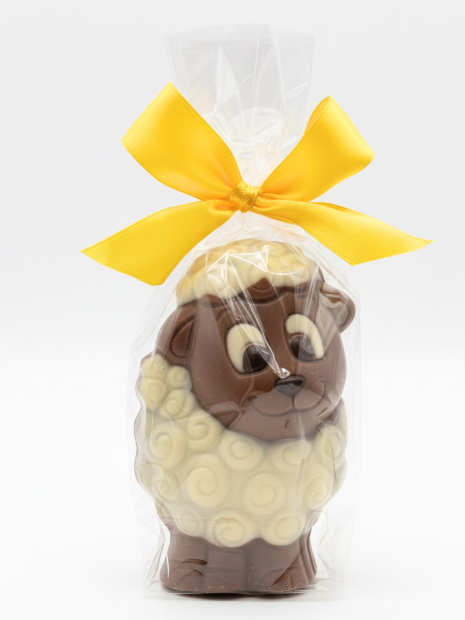 Schokoladen-Schaf „Dolly“ 75g von Sweet-Konzept, niedliche Schokofigur aus Edelvollmilch-Schokolade in Folie mit gelber Schleife, erhältlich in der Dreyer Confiserie in der Rattenfängerstadt Hameln.