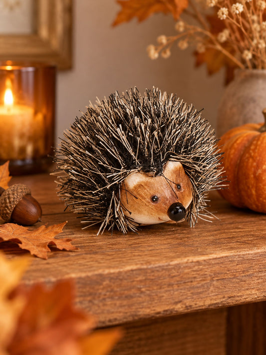 Verkaufsbild von Brauner Deko-Igel aus Ton und Kunstfell 6x4x5cm von G. Wurm auf Tisch und herbstlichem Hintergrund