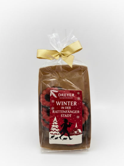 Verpackung von X-Mas Schokoringe Zartbitter rot 100 g – handveredelte Schokoringe aus feinherber Schokolade mit weihnachtlicher Deko, erhältlich bei Dreyer Confiserie Hameln.